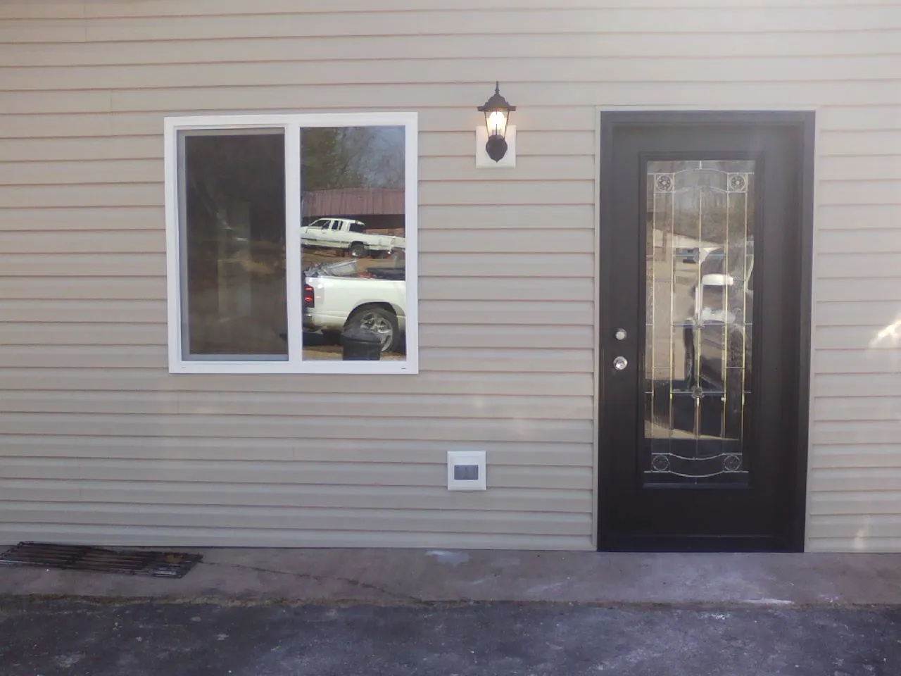 New siding, window and entry door on the side of an addition in Prompton
