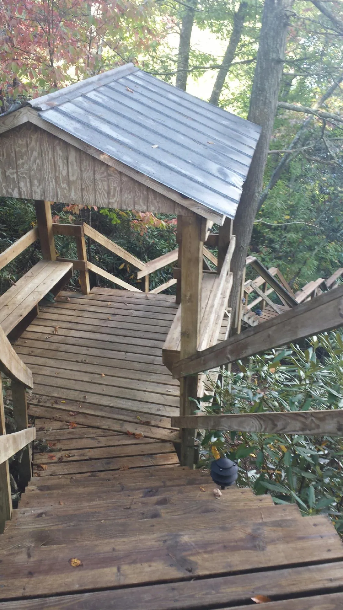 Metal roofed shelter over wooden steps on a wooded walkway — Skylight Repair & Installation work by our crew in Prompton