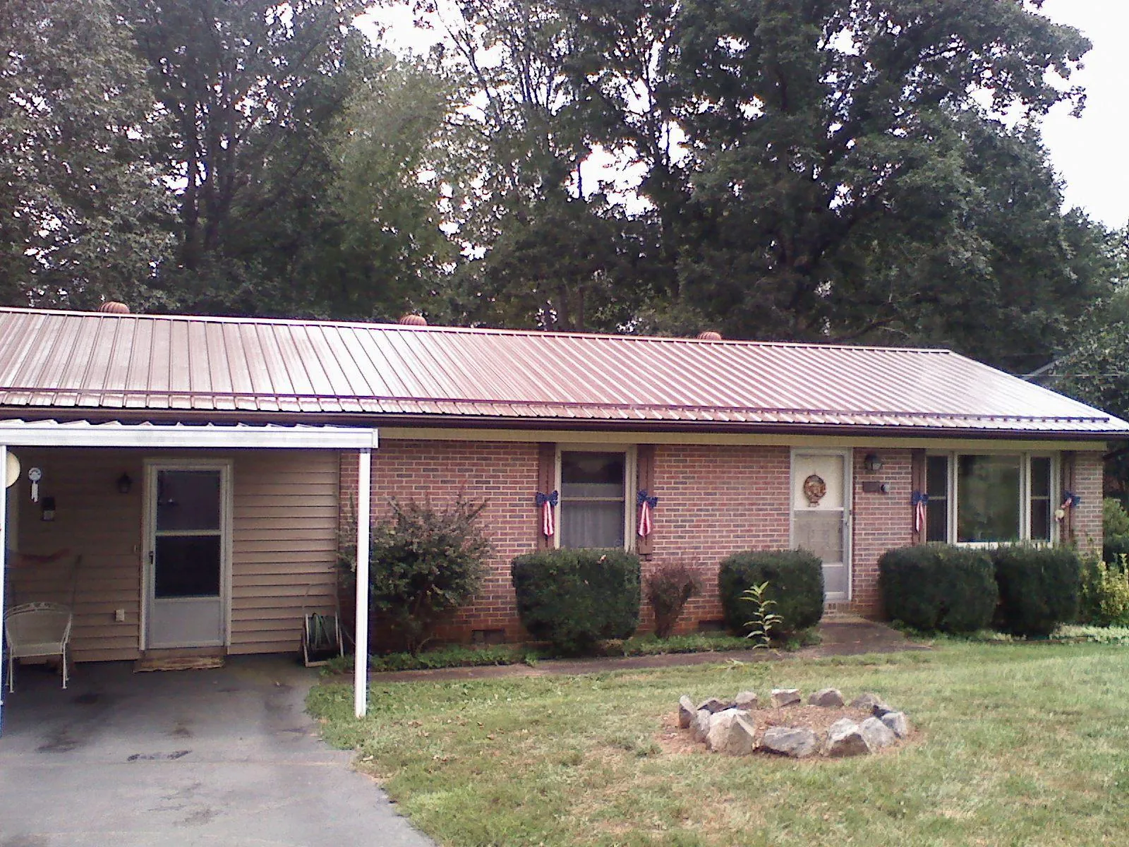 Bronze metal roof and carport on a brick ranch home — Roof Repair work by our crew in Prompton
